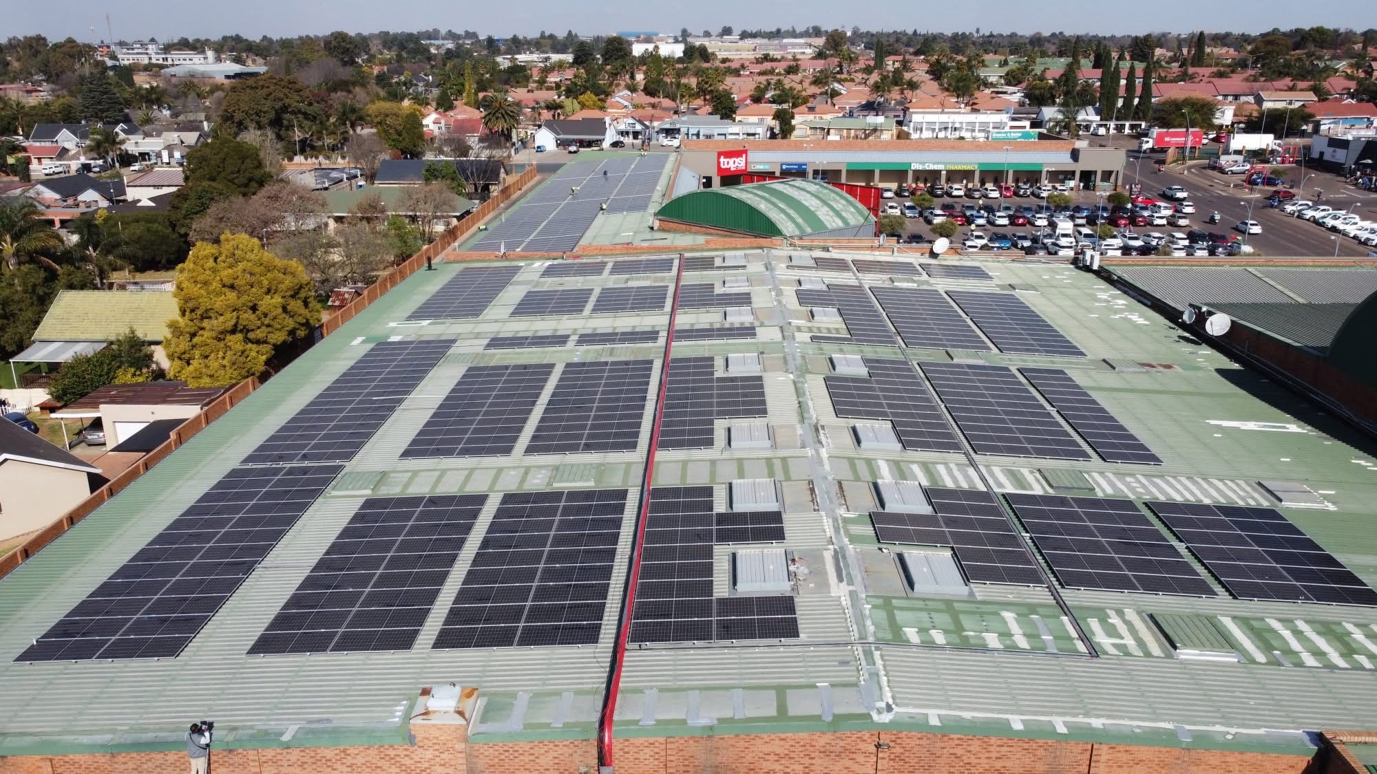 Aerial view of a large rooftop solar PV installation on a retail centre