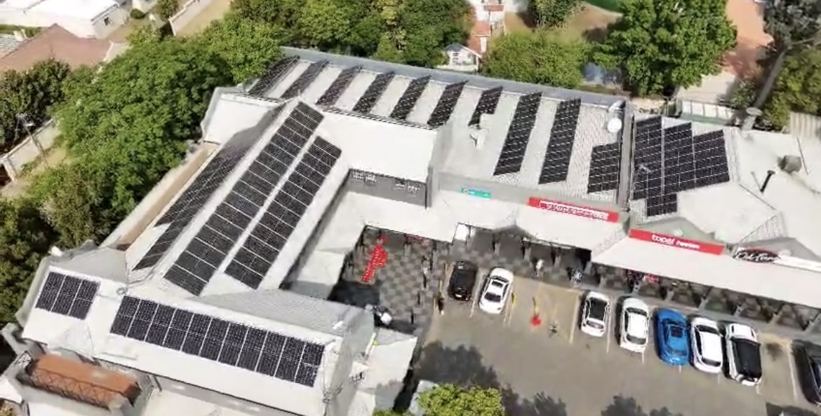 Aerial view of solar panels across a neighbourhood shopping centre roof